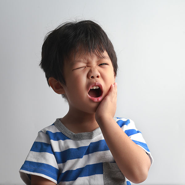 Young Boy experiencing tooth pain.